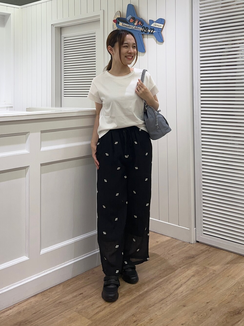 ホワイト系のTシャツ/カットソー、ブラック系のその他パンツ、ブルー系のショルダーバッグを着用したレディースの夏コーディネートの1枚目の写真