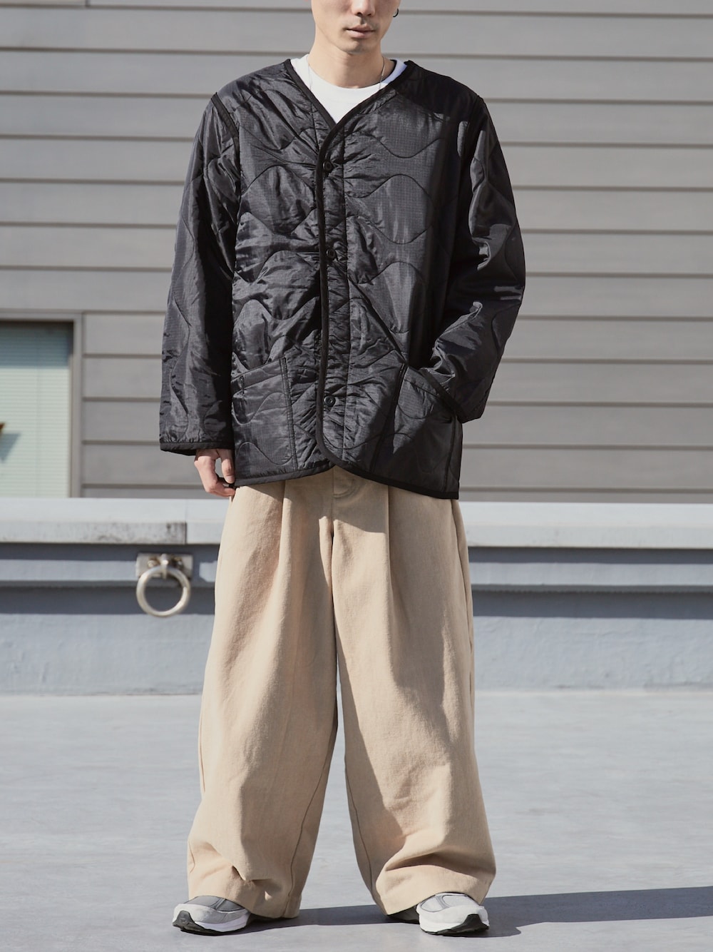 ブラック系のミリタリージャケット、ホワイト系のTシャツ/カットソーを着用したメンズの冬コーディネートの1枚目の写真