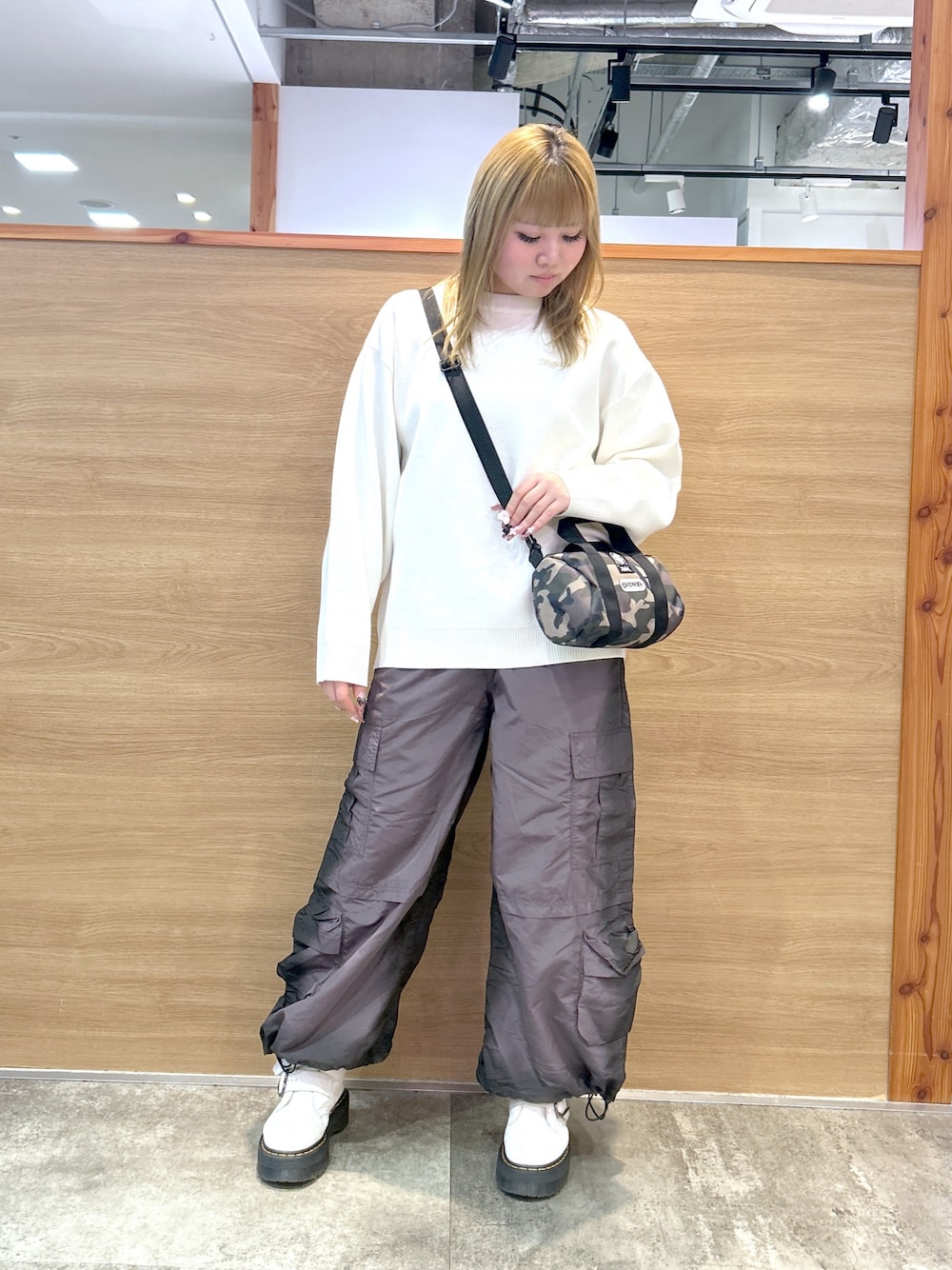 ホワイト系のニット/セーター、その他のショルダーバッグ、ブラック系のカーゴパンツを着用したレディースの冬コーディネートの1枚目の写真