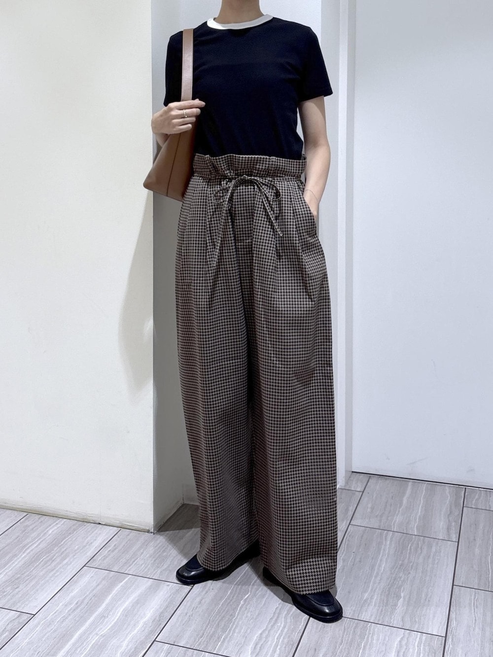 ブラック系のローファー、ブラウン系のスラックス、ブラック系のTシャツ/カットソーを着用したレディースの夏コーディネートの1枚目の写真