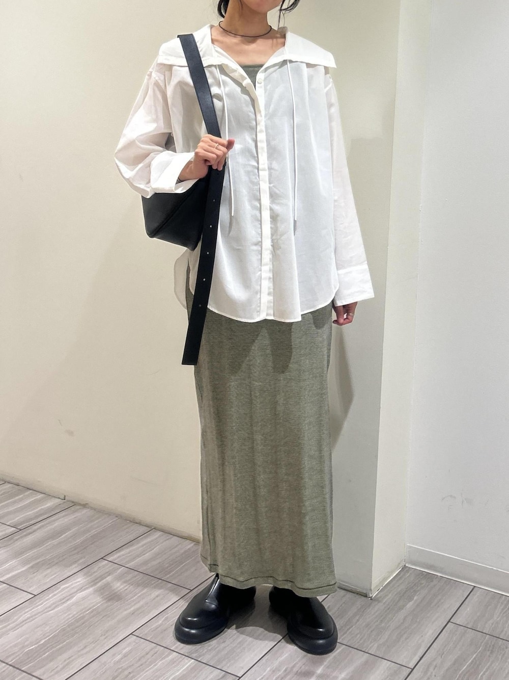 ホワイト系のシャツ/ブラウス、グリーン系のタンクトップ、グリーン系のスカートを着用したレディースの春コーディネートの1枚目の写真