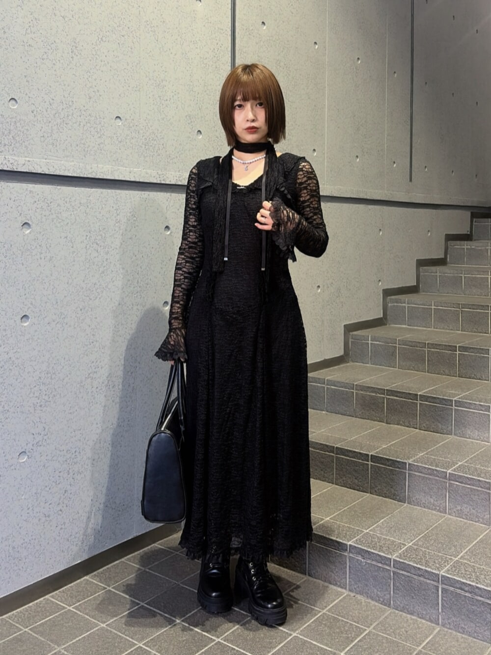 ブラック系のブーツ、ブラック系のハンドバッグ、ブラック系のワンピースを着用したレディースの秋コーディネートの1枚目の写真