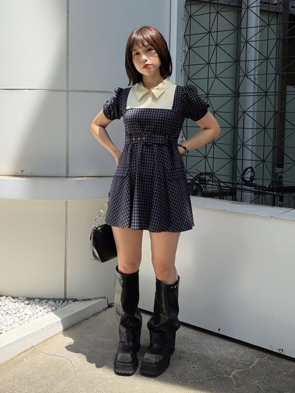 ブルー系のワンピース、ブラック系のハンドバッグ、ブラック系のブーツを着用したレディースの夏コーディネートの1枚目の写真