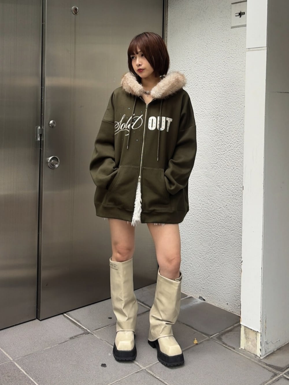 ホワイト系のスカート、ベージュ系のTシャツ/カットソー、ホワイト系のブーツを着用したレディースの秋コーディネートの1枚目の写真