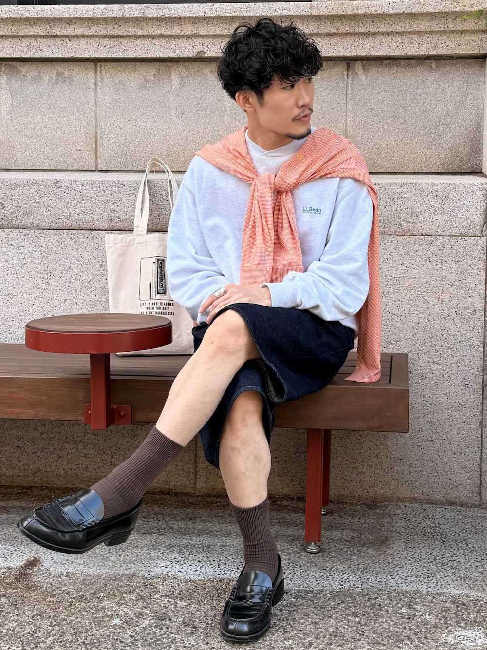 グレー系のスウェット、ブルー系のデニムパンツ、ブラック系のローファーを着用したメンズの秋コーディネートの1枚目の写真