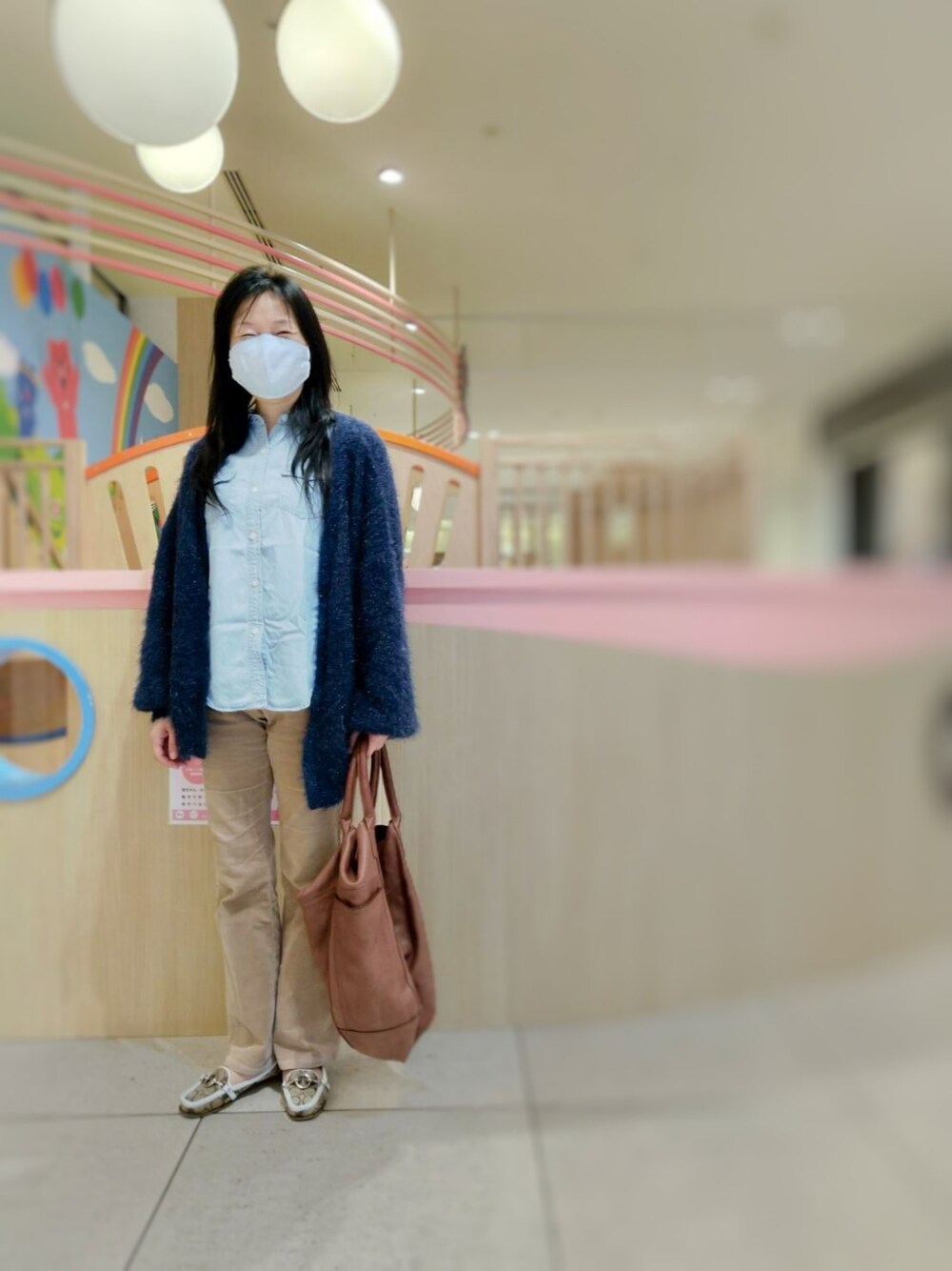 ブルー系のその他アウター、ベージュ系のパンツ、ブラウン系のローファーを着用したレディースの春コーディネートの1枚目の写真