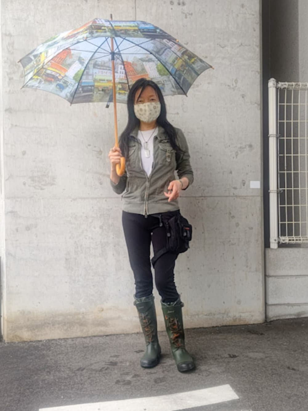 ブラック系のボディバッグ/ウエストポーチ、ブラック系のパンツ、グリーン系のミリタリージャケットを着用したレディースの春コーディネートの1枚目の写真