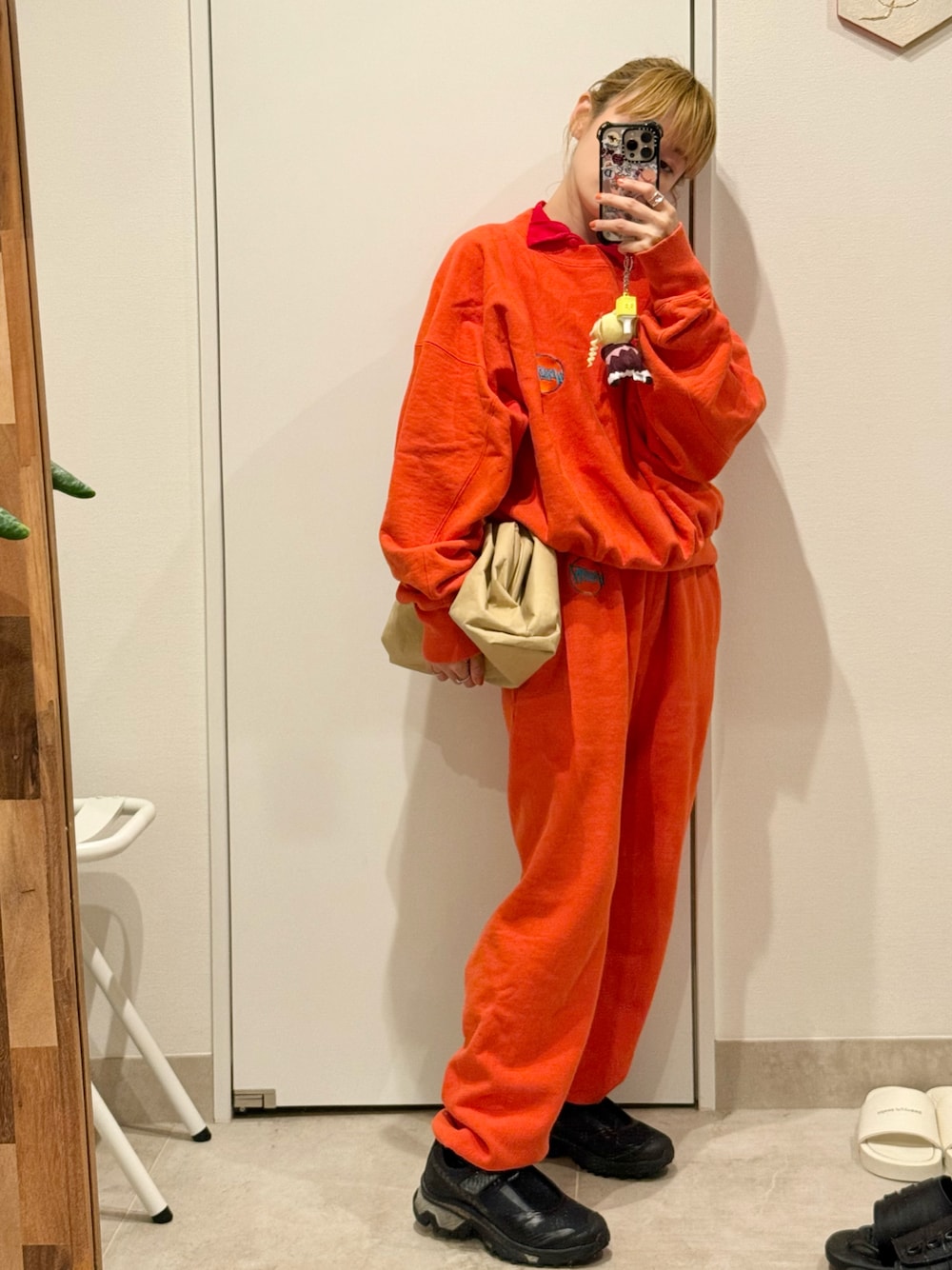 「セットアップ、HOLIDAY、オレンジ、ホリデー、スウェット、MM6、SALOMON、BOTTEGA VENETA」｜「HOLIDAYのULTRA HEAVY SWEAT CREW-NECK TOPS (CIRCLE LOGO) ウルトラヘビースウェットクルーネックトップス (サークルロゴ)（スウェット、オレンジ系）」を使った、高橋愛さん（レディース・154cm）の春コーディネートの1枚目の写真