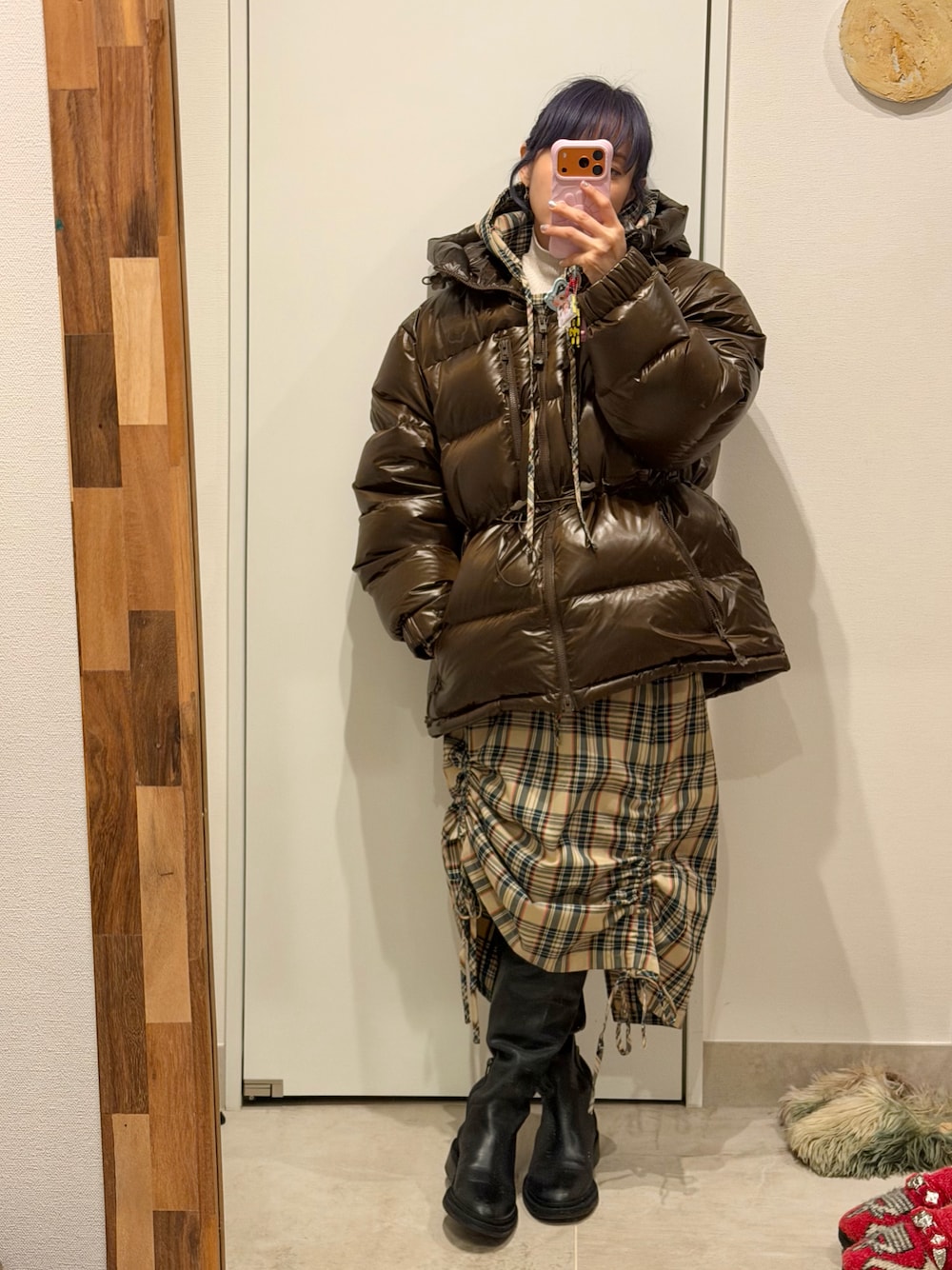 ベージュ系のスカート、ベージュ系のトップス、ブラック系のブーツを着用したレディースの冬コーディネートの1枚目の写真