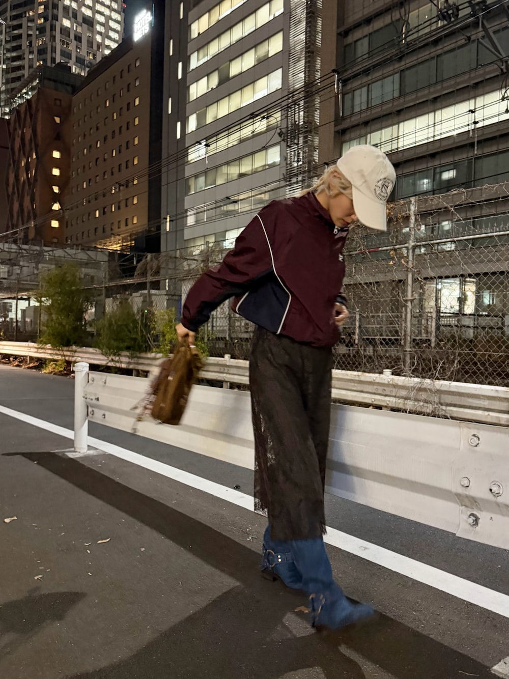 レッド系のジャージ、ブラウン系のワンピース/ドレス、グレー系のパンツを着用したレディースの冬コーディネートの1枚目の写真