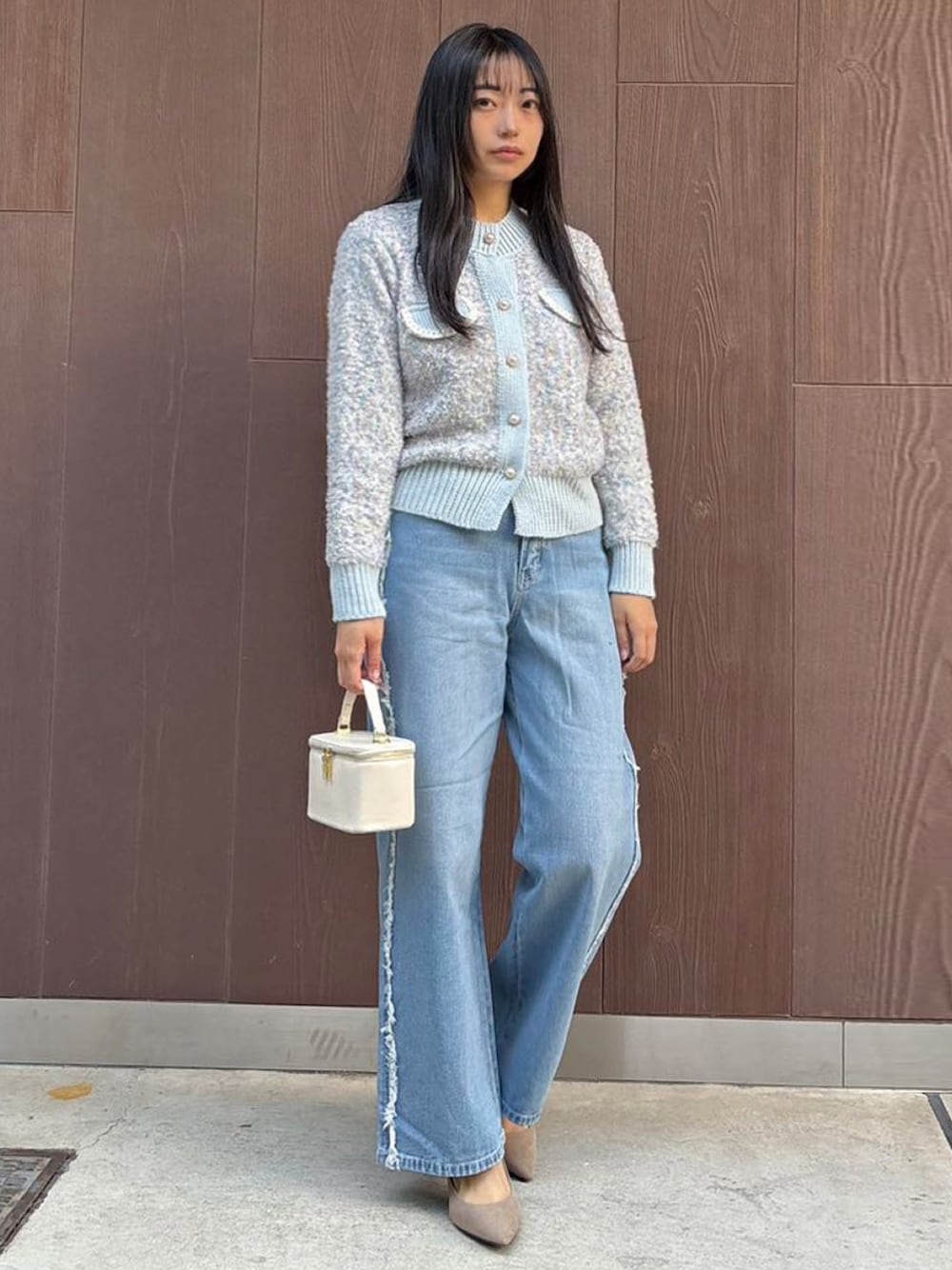 ブルー系のカーディガン/ボレロ、ホワイト系のショルダーバッグ、ブルー系のデニムパンツを着用したレディースの冬コーディネートの1枚目の写真