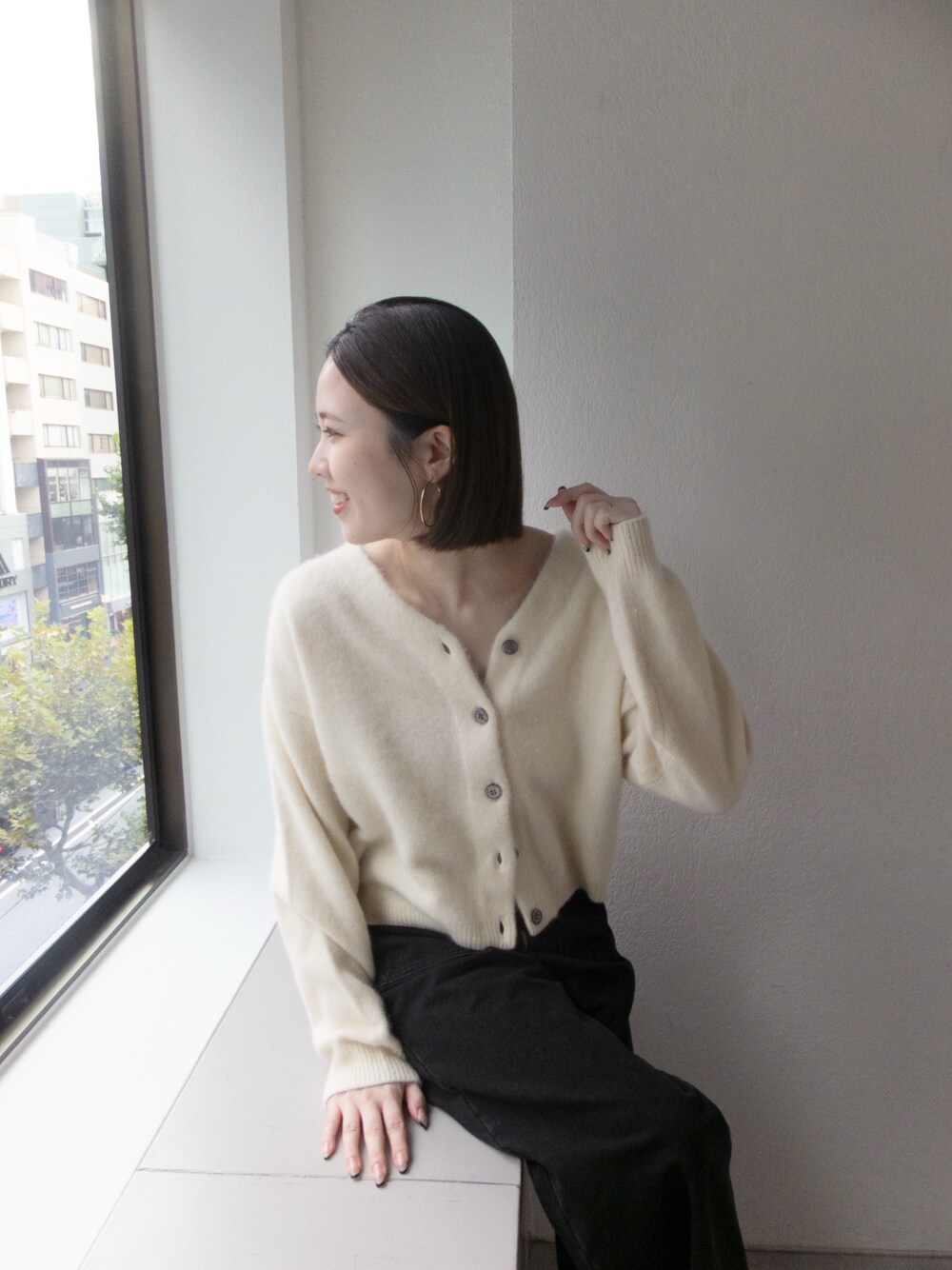 ホワイト系のカーディガン/ボレロ、グレー系のデニムパンツを着用したレディースの秋コーディネートの1枚目の写真