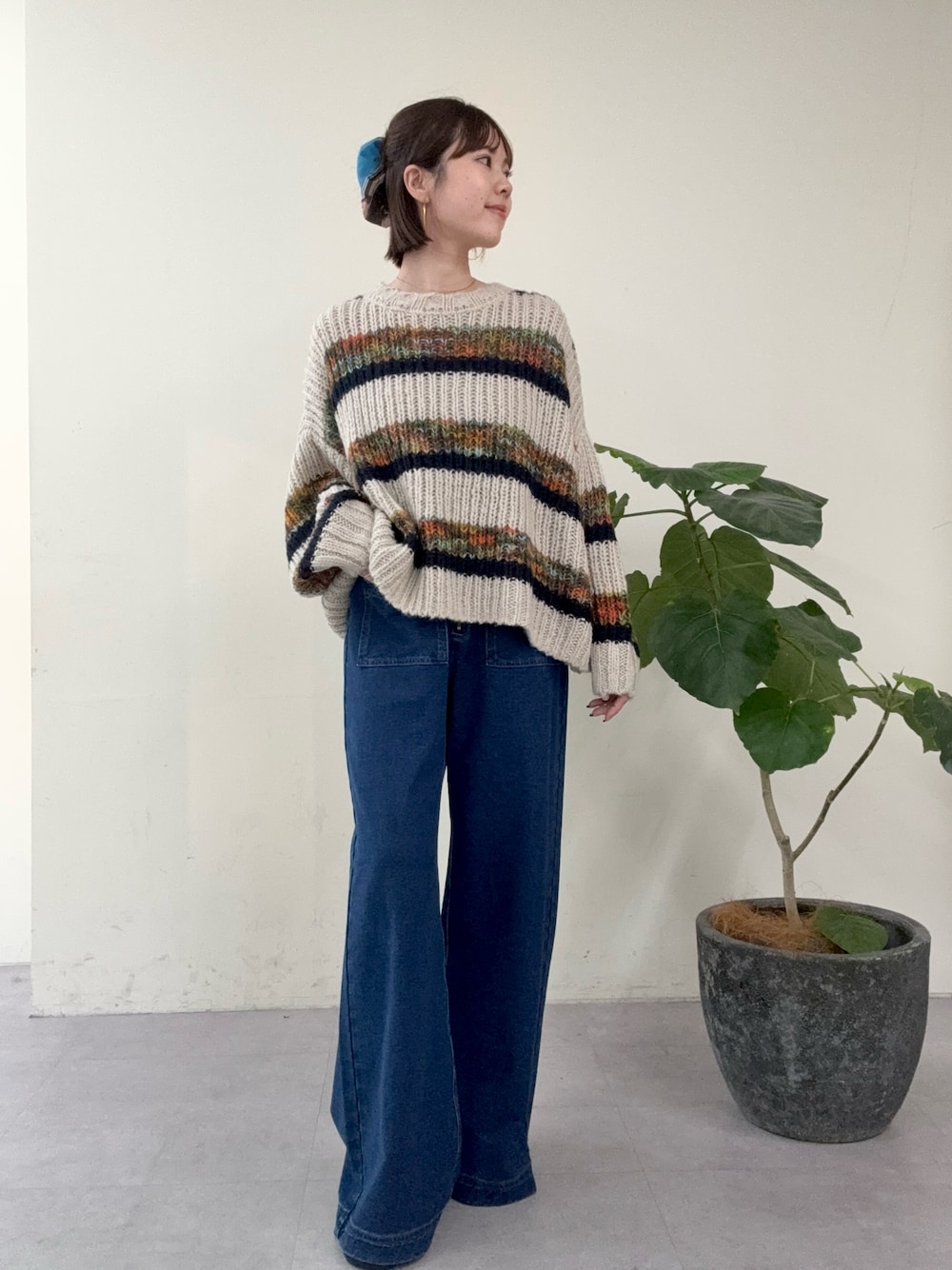 ブルー系のニット/セーター、ブルー系のデニムパンツを着用したレディースの秋コーディネートの1枚目の写真