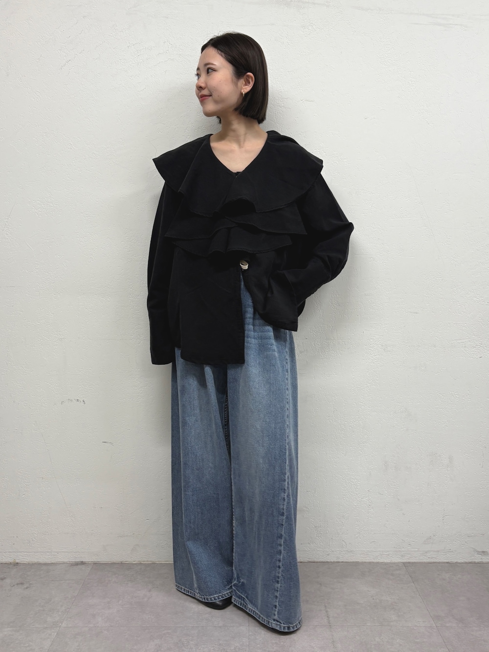 ブラック系のシャツ/ブラウス、ブルー系のデニムパンツ、ブラック系のパンプスを着用したレディースの秋コーディネートの1枚目の写真