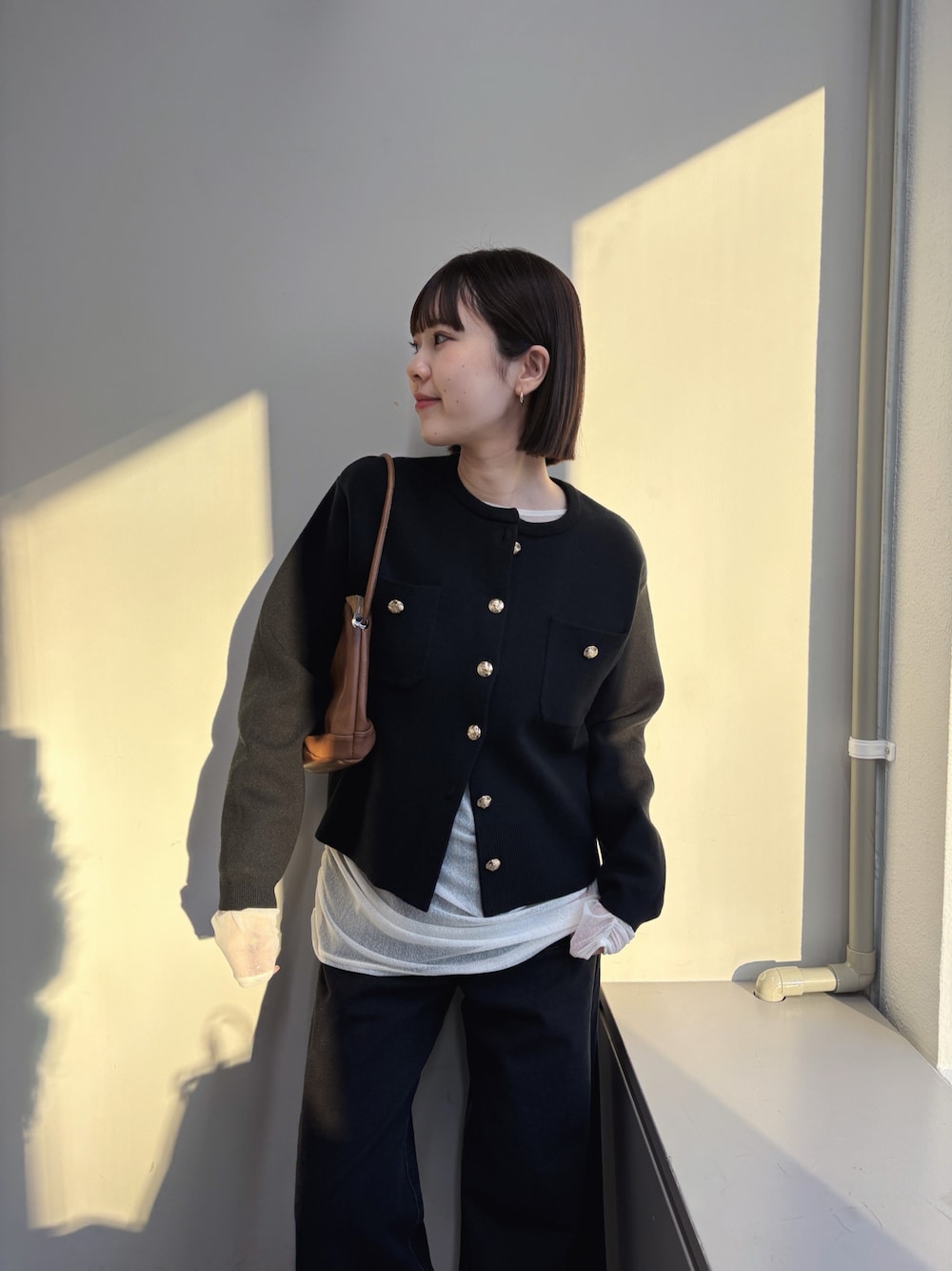 ブラック系のカーディガン/ボレロ、ホワイト系のTシャツ/カットソー、グレー系のデニムパンツを着用したレディースの秋コーディネートの1枚目の写真