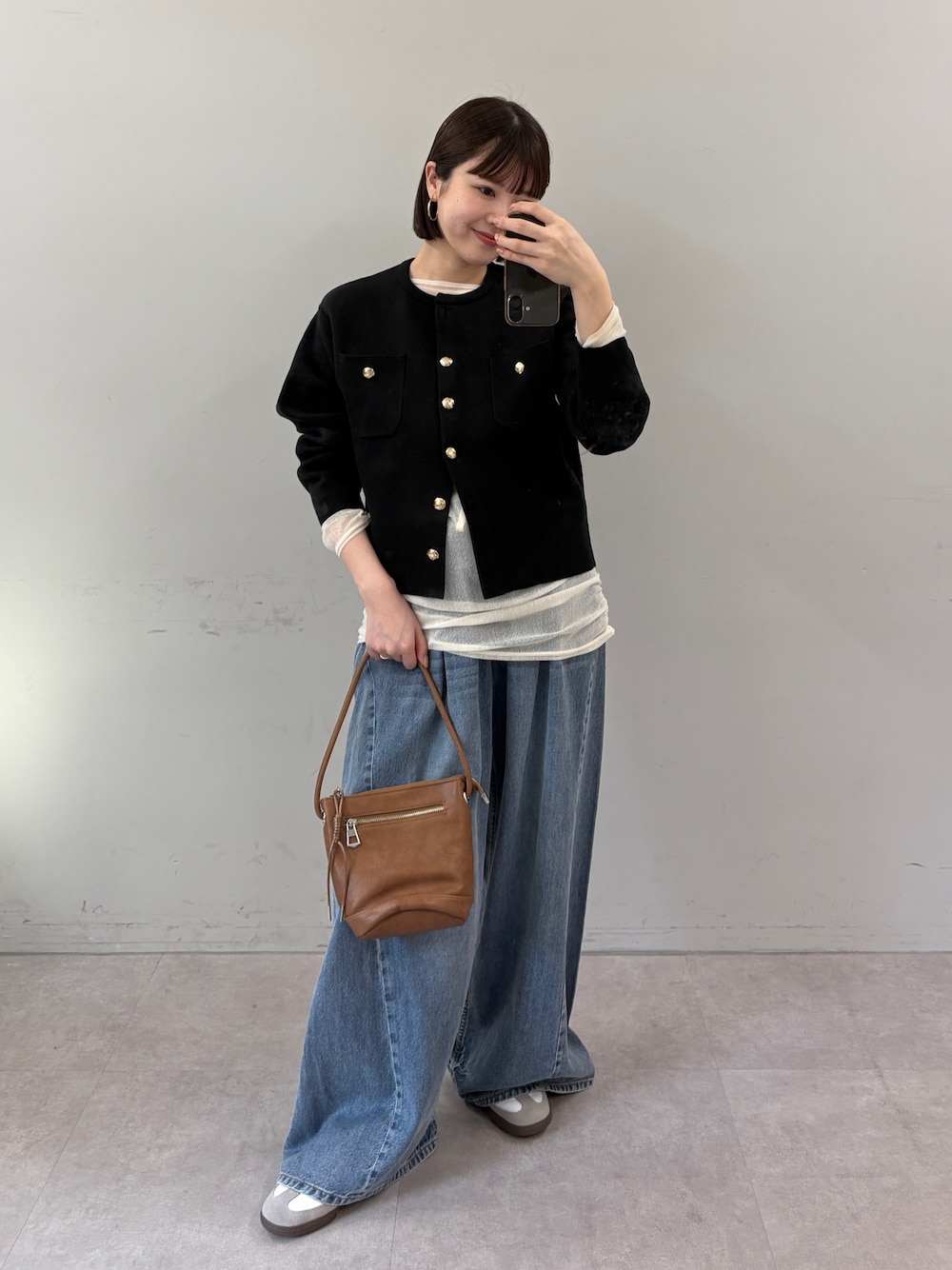 ブラック系のカーディガン/ボレロ、ホワイト系のTシャツ/カットソー、ブルー系のデニムパンツを着用したレディースの秋コーディネートの1枚目の写真