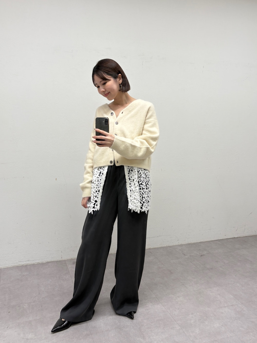 ホワイト系のカーディガン/ボレロ、ブラック系のキャミソール、グレー系のその他パンツを着用したレディースの秋コーディネートの1枚目の写真