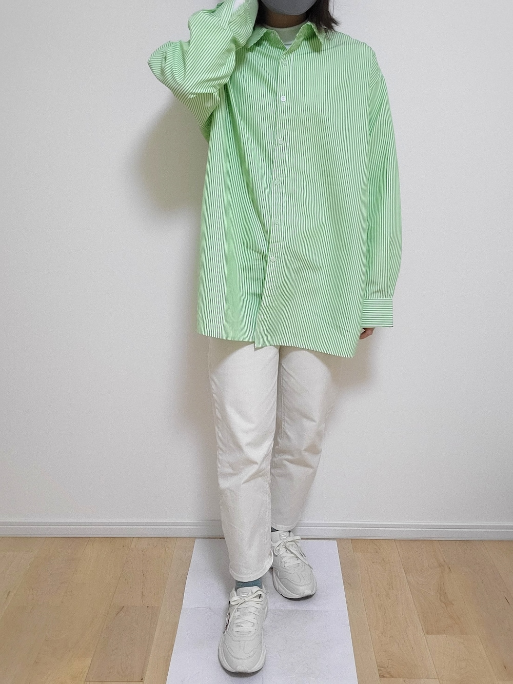 グリーン系のシャツ/ブラウス、ベージュ系のチノパンツ、ホワイト系のスニーカーを着用したレディースの春コーディネートの2枚目の写真