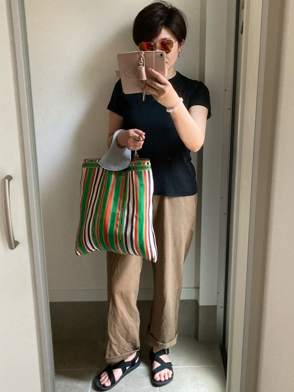 ブラウン系のパンツ、ブラック系のTシャツ/カットソーを着用したレディースの夏コーディネートの1枚目の写真