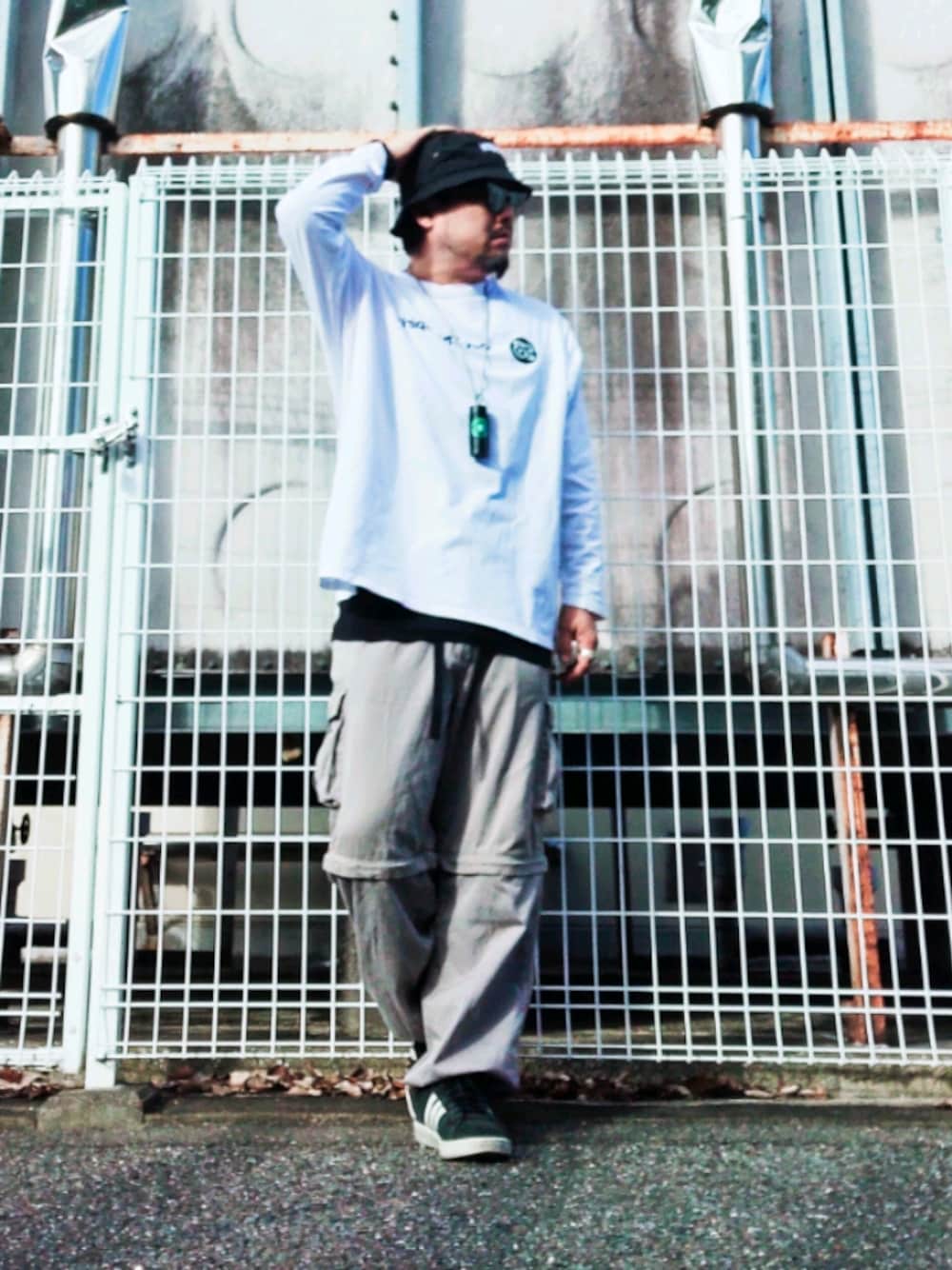 ホワイト系のTシャツ/カットソー、ブラック系のタンクトップ、グレー系のカーゴパンツを着用したメンズの秋コーディネートの1枚目の写真