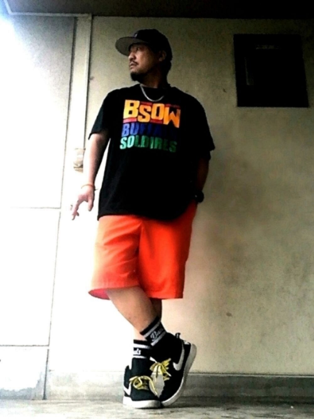 ブラック系のTシャツ/カットソー、オレンジ系のその他パンツ、ブラック系のスニーカーを着用したメンズの夏コーディネートの1枚目の写真