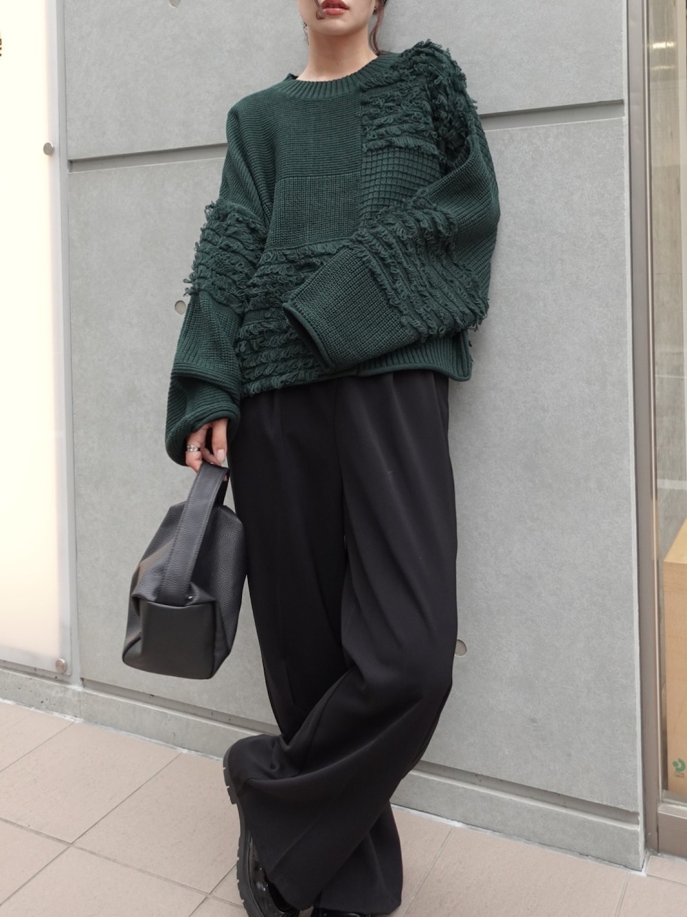 ブラック系のショルダーバッグ、ブラック系のスラックス、グリーン系のニット/セーターを着用したレディースの秋コーディネートの1枚目の写真