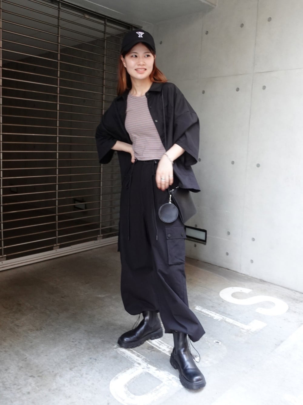 ブラウン系のトップス、ブラック系のカーゴパンツ、ブラック系のショルダーバッグを着用したレディースの夏コーディネートの1枚目の写真