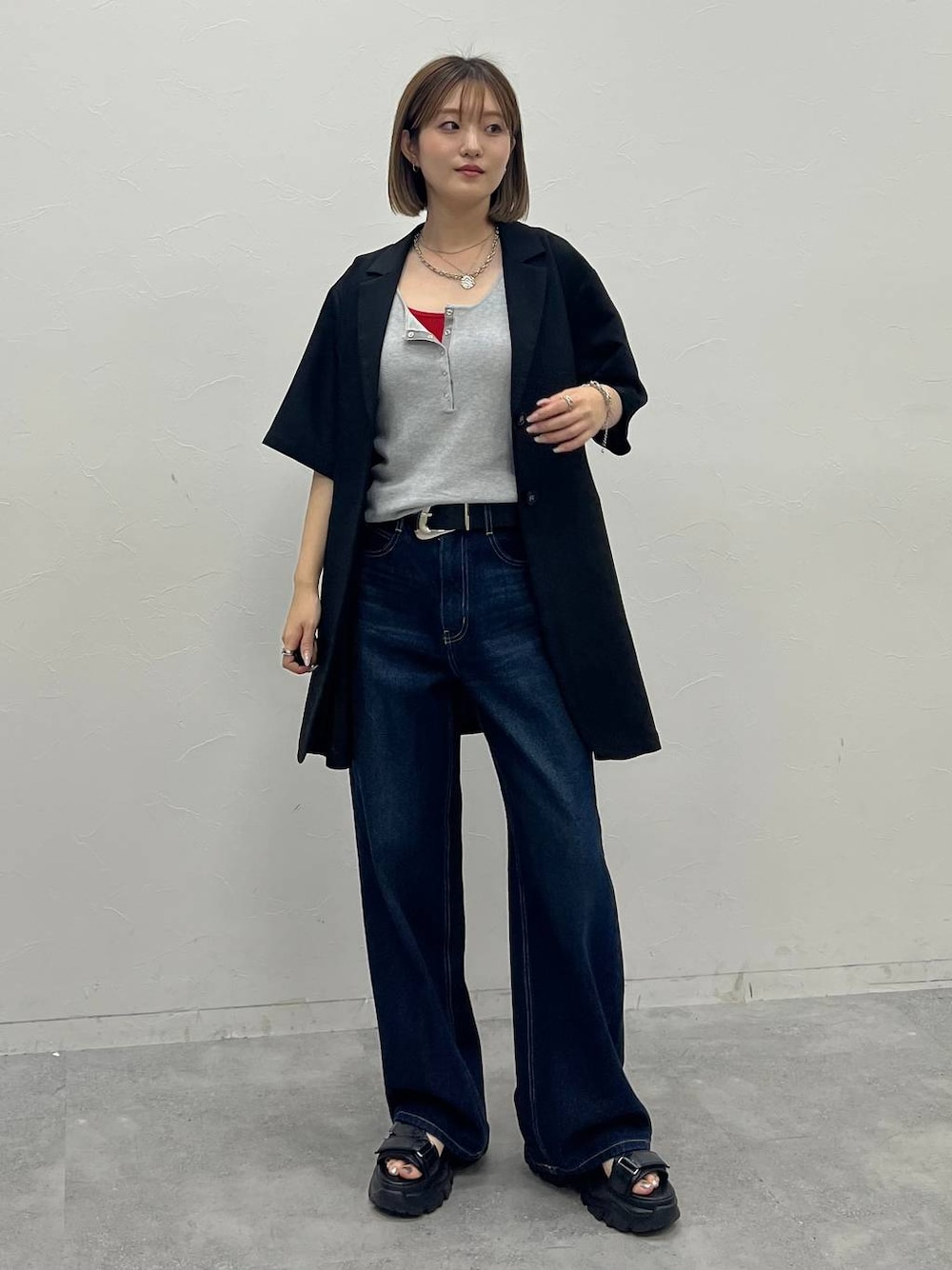 レッド系のキャミソール、ブルー系のデニムパンツ、グレー系のタンクトップを着用したレディースの夏コーディネートの1枚目の写真