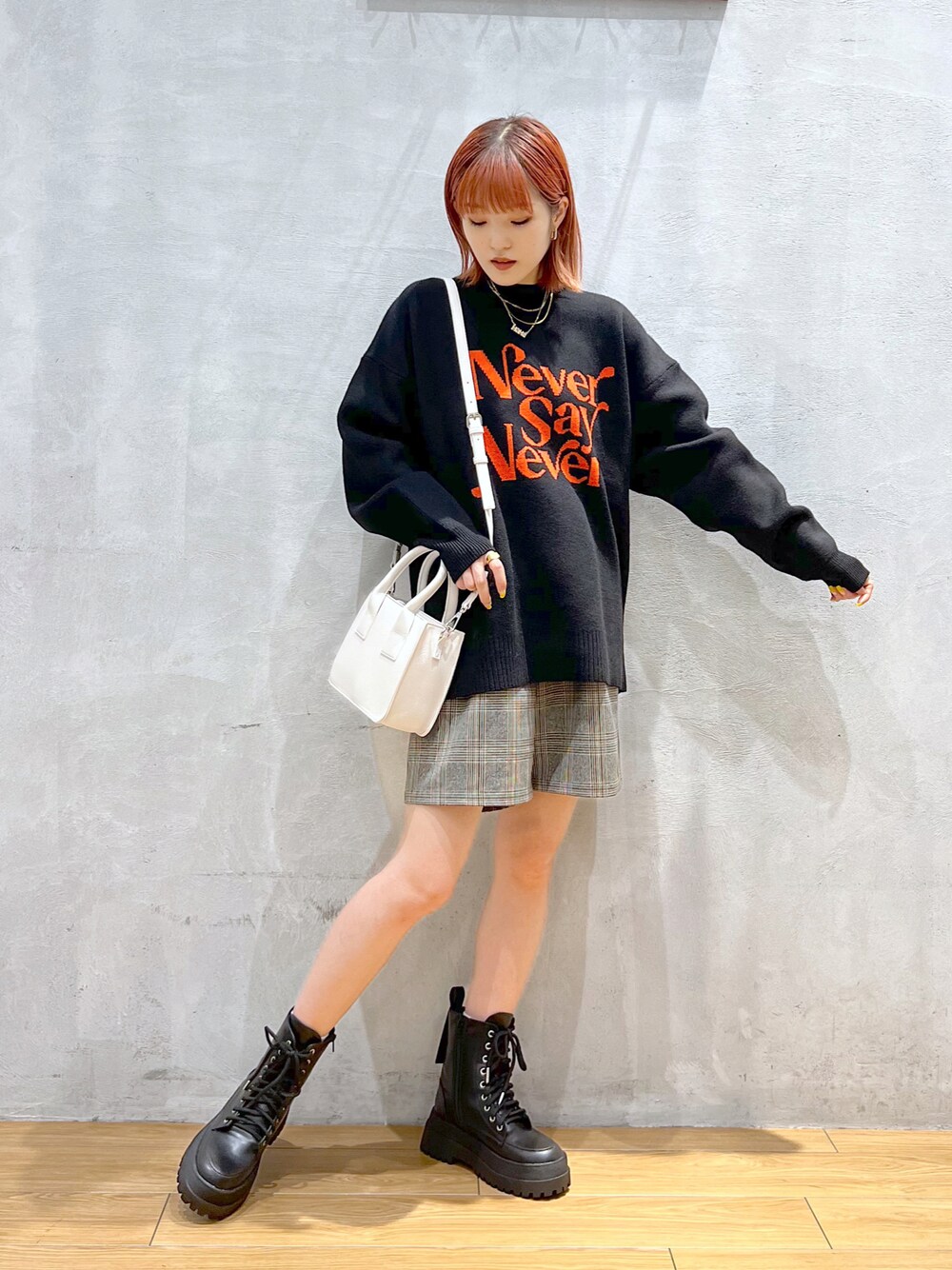 ブラック系のニット/セーター、グレー系のその他パンツ、ホワイト系のショルダーバッグを着用したレディースの冬コーディネートの1枚目の写真