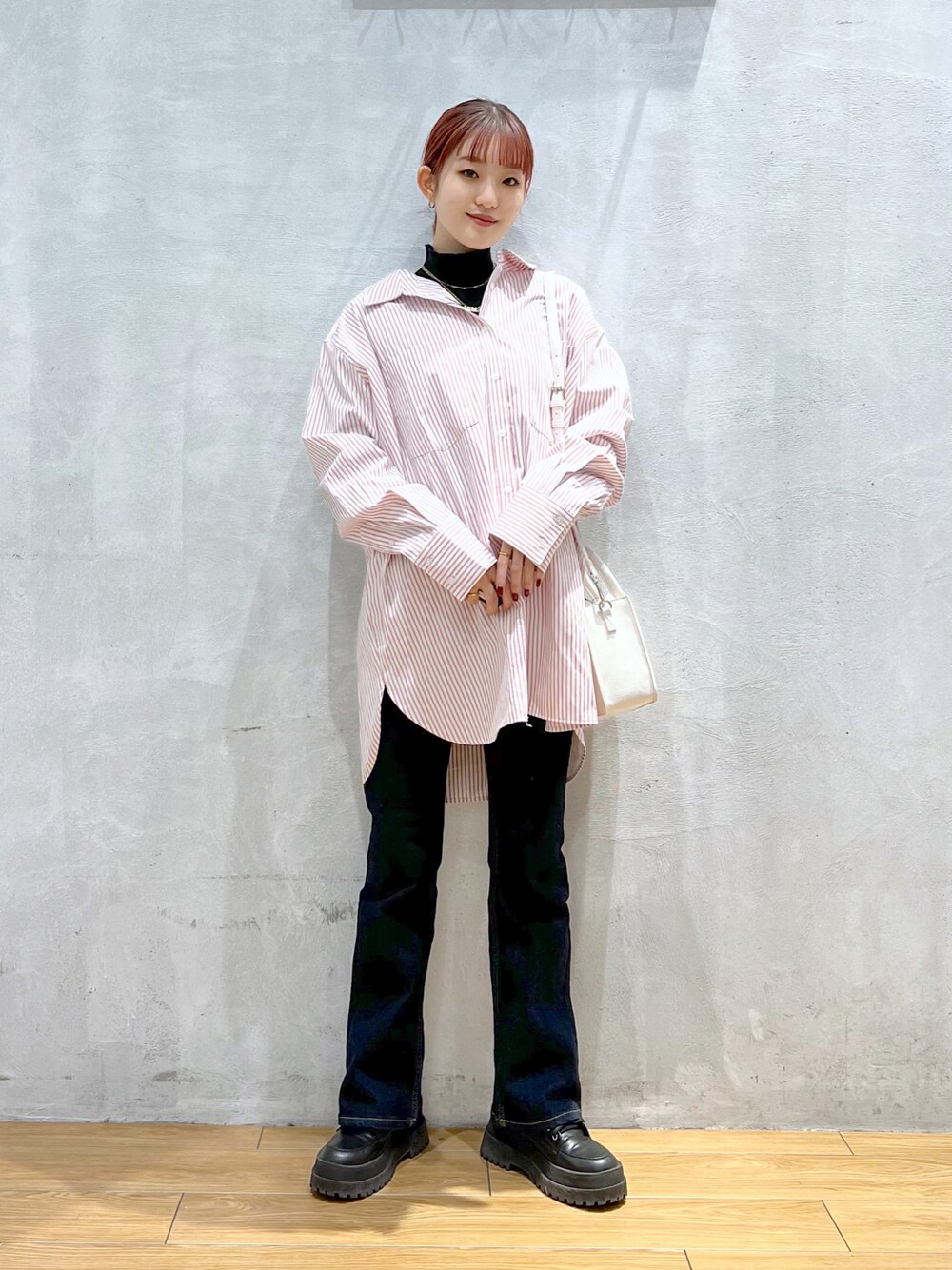 ブルー系のデニムパンツ、ピンク系のシャツ/ブラウス、ブラック系のニット/セーターを着用したレディースの冬コーディネートの1枚目の写真