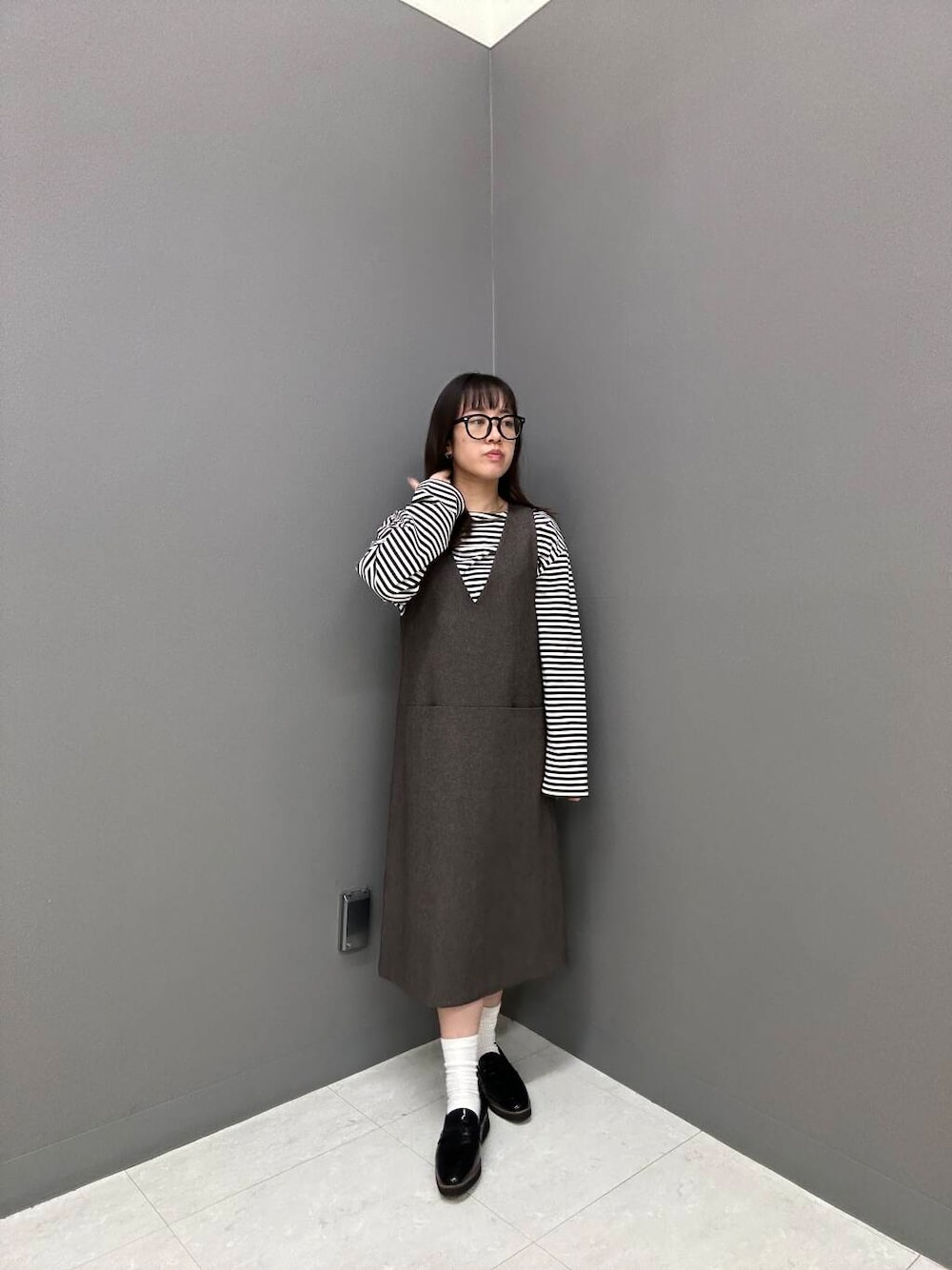 ブラック系のローファー、ホワイト系のTシャツ/カットソー、ブラウン系のワンピースを着用したレディースの秋コーディネートの1枚目の写真