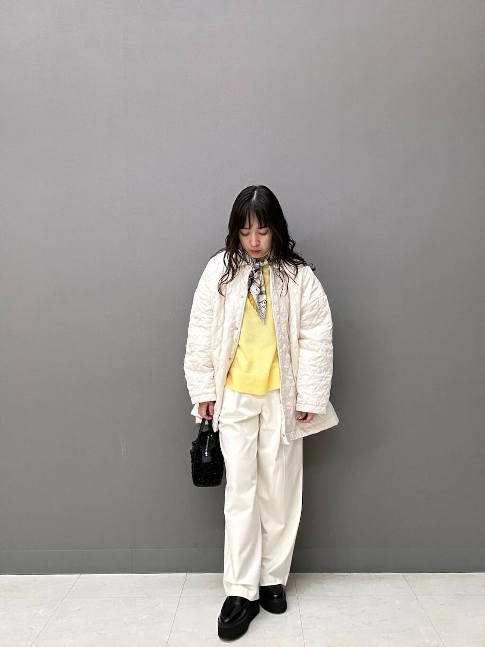 ホワイト系のダウンジャケット/コート、ホワイト系のその他パンツ、ブラック系のハンドバッグを着用したレディースの秋コーディネートの1枚目の写真