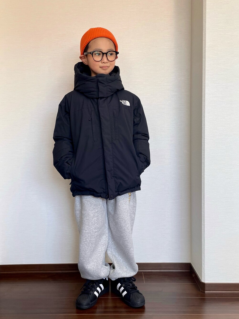ブラック系のダウンジャケット/コート、グレー系のスウェットパンツ、ブラック系のスニーカーを着用したキッズの冬コーディネートの1枚目の写真