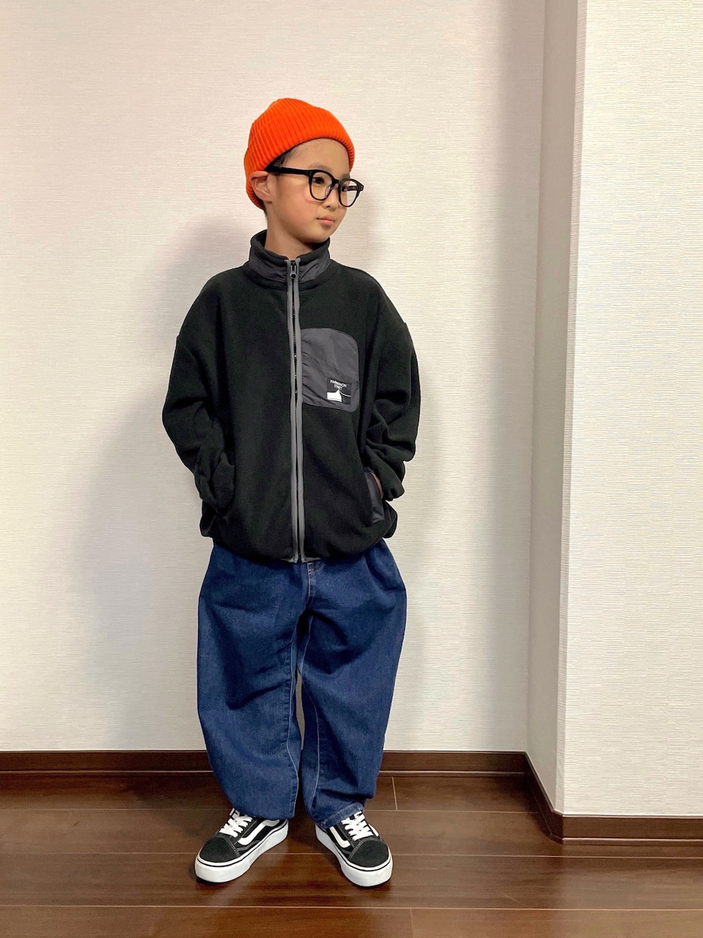 ブラック系のその他アウター、ブルー系のデニムパンツ、ブラック系のスニーカーを着用したキッズの秋コーディネートの1枚目の写真