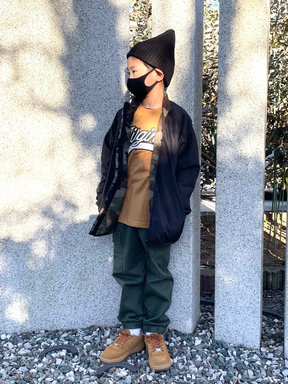 イエロー系のTシャツ/カットソー、グリーン系のブルゾン、グリーン系のカーゴパンツを着用したキッズの冬コーディネートの1枚目の写真