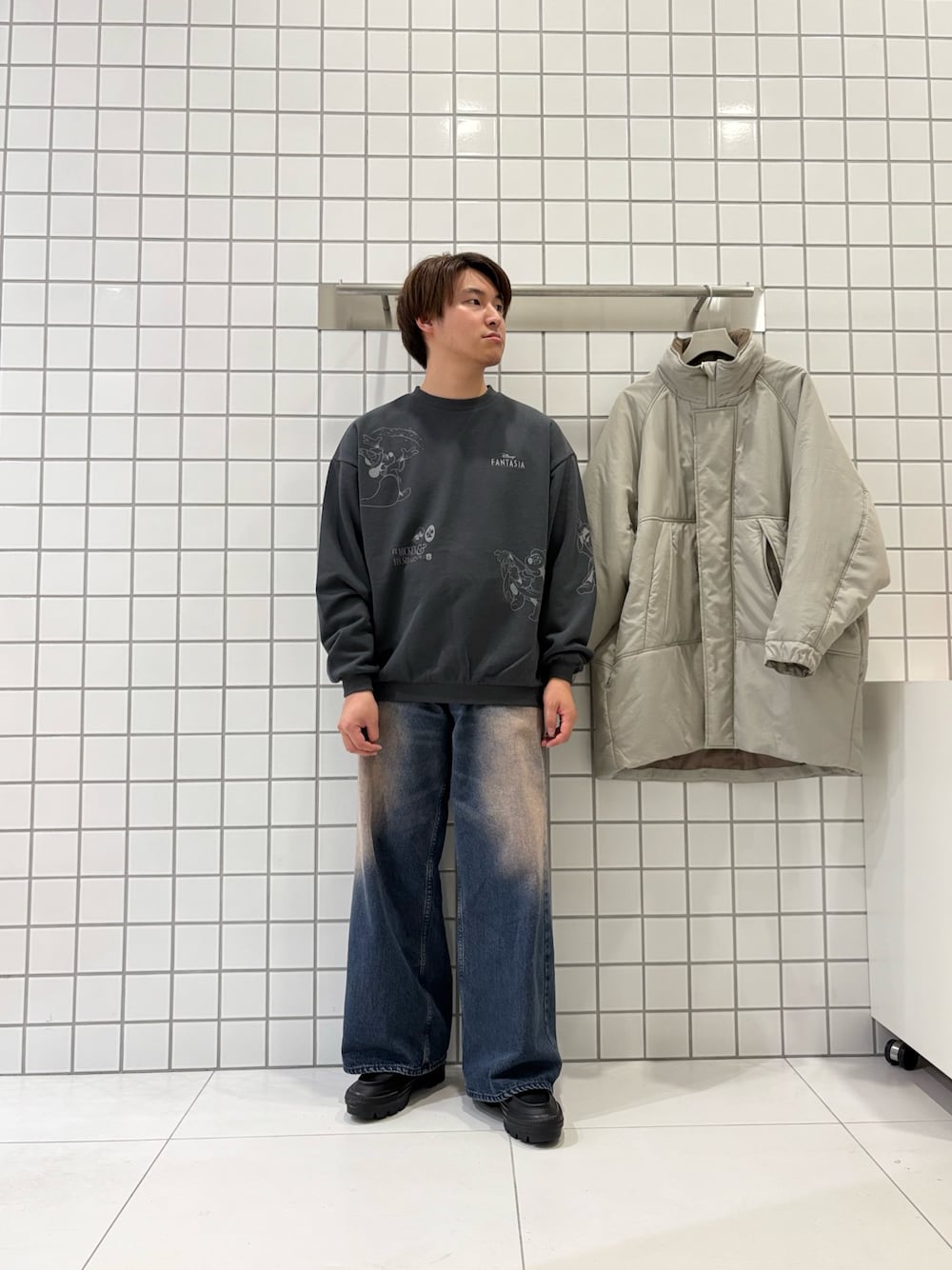 グレー系のスウェット、ブルー系のデニムパンツ、ベージュ系のダウンジャケット/コートを着用したメンズの秋コーディネートの1枚目の写真