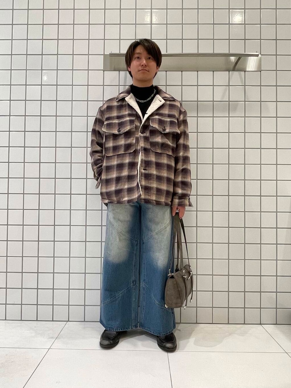 ブラック系のニット/セーター、ブルー系のその他パンツ、ブラウン系のボストンバッグを着用したメンズの冬コーディネートの1枚目の写真