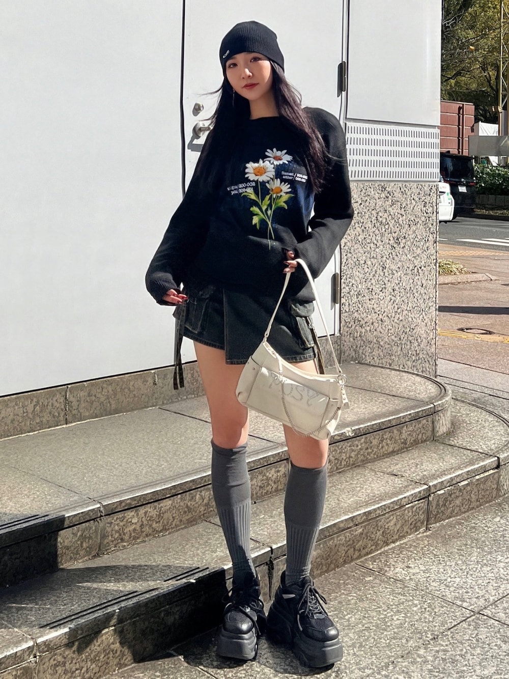 ブラック系のニット/セーター、ブルー系のその他パンツ、ブラック系のスニーカーを着用したレディースの春コーディネートの1枚目の写真