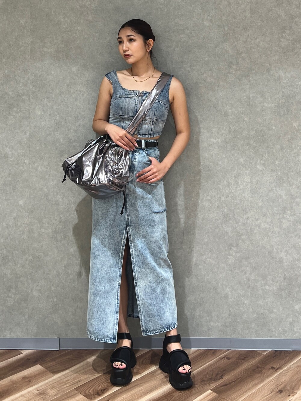 ブルー系のキャミソール、ブルー系のデニムスカート、シルバー系のハンドバッグを着用したレディースの夏コーディネートの1枚目の写真