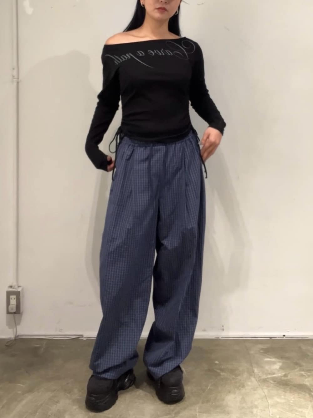 ブルー系のその他パンツ、ブラック系のTシャツ/カットソー、ブラック系のスニーカーを着用したレディースの春コーディネートの1枚目の写真