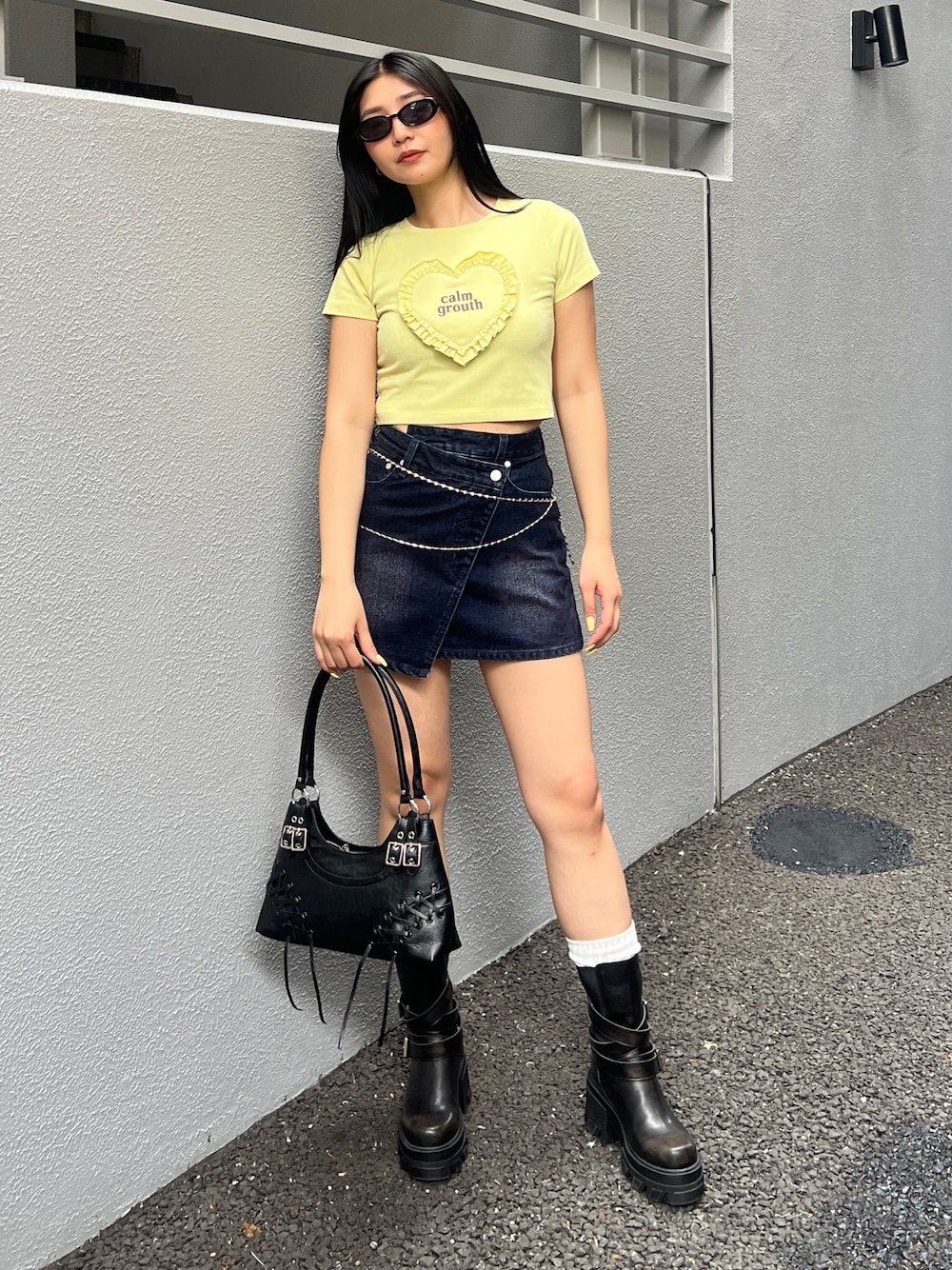 イエロー系のTシャツ/カットソー、ブルー系のスカート、ブラック系のブーツを着用したレディースの夏コーディネートの1枚目の写真