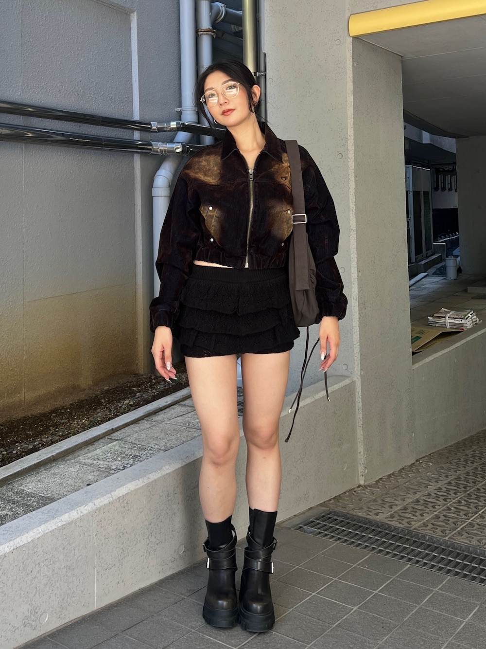 ブラウン系のブルゾン、ブラック系のスカート、ブラック系のブーツを着用したレディースの夏コーディネートの1枚目の写真