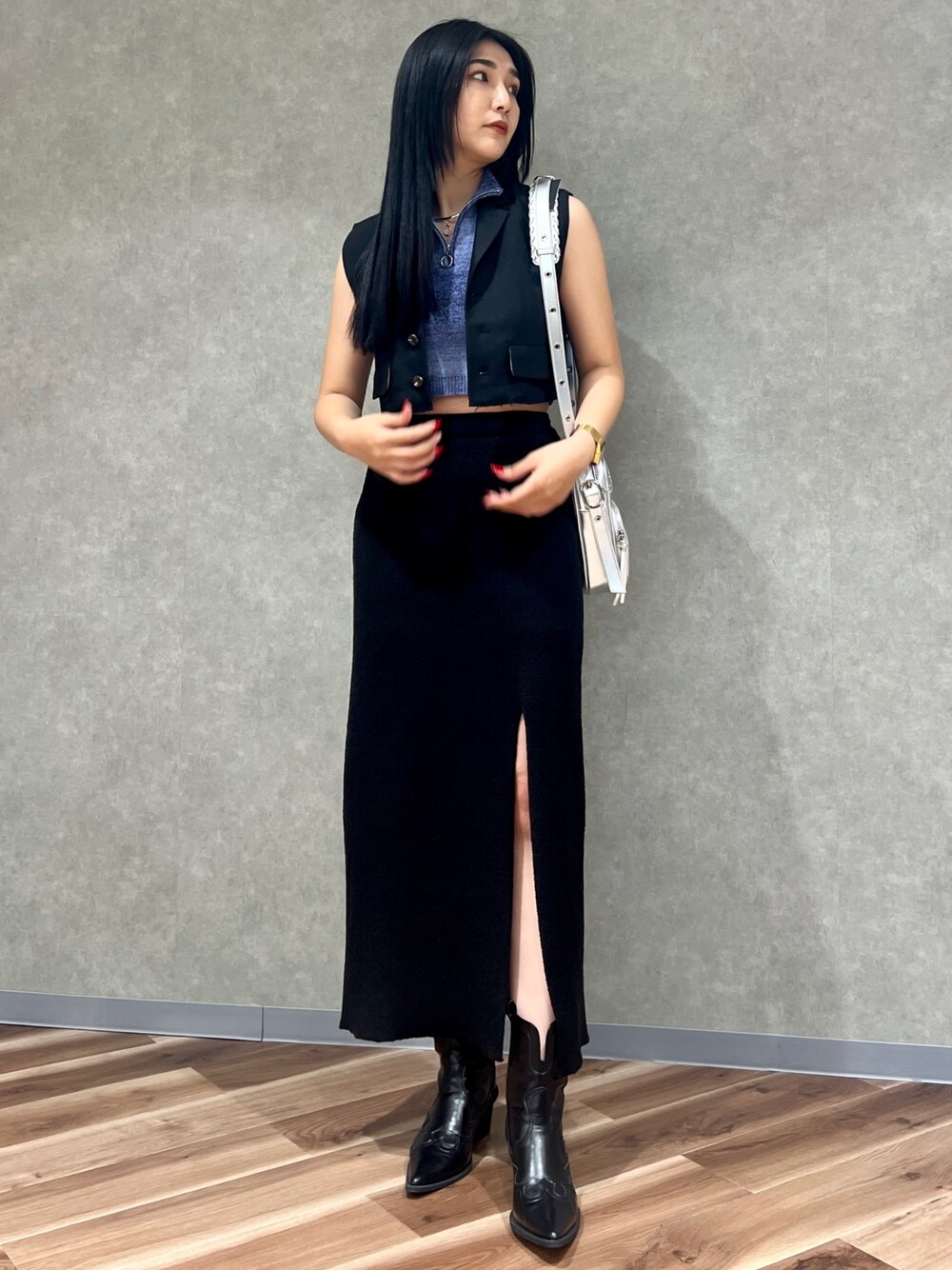 ブラック系のスカート、シルバー系のショルダーバッグ、ブラック系のブーツを着用したレディースの夏コーディネートの1枚目の写真