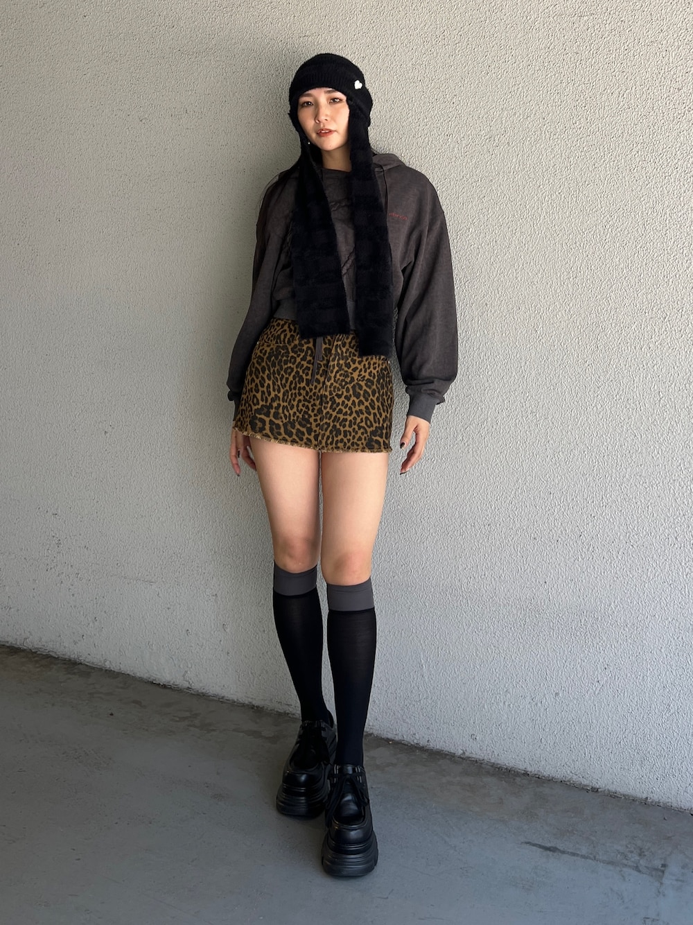 ブラック系のパーカー、ベージュ系のスカート、ブラック系のローファーを着用したレディースの夏コーディネートの1枚目の写真