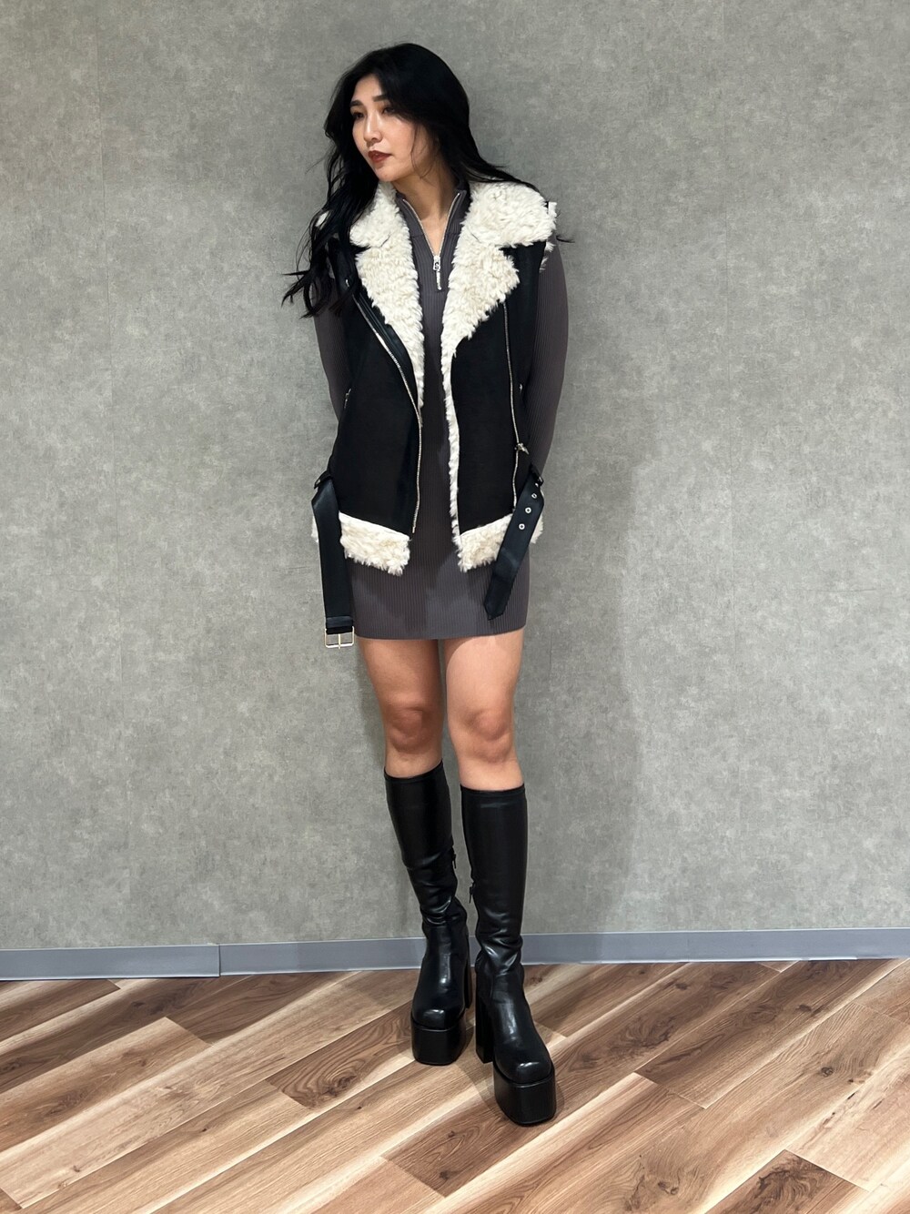 ブラック系のムートンコート、ブラック系のブーツ、グレー系のワンピースを着用したレディースの秋コーディネートの1枚目の写真