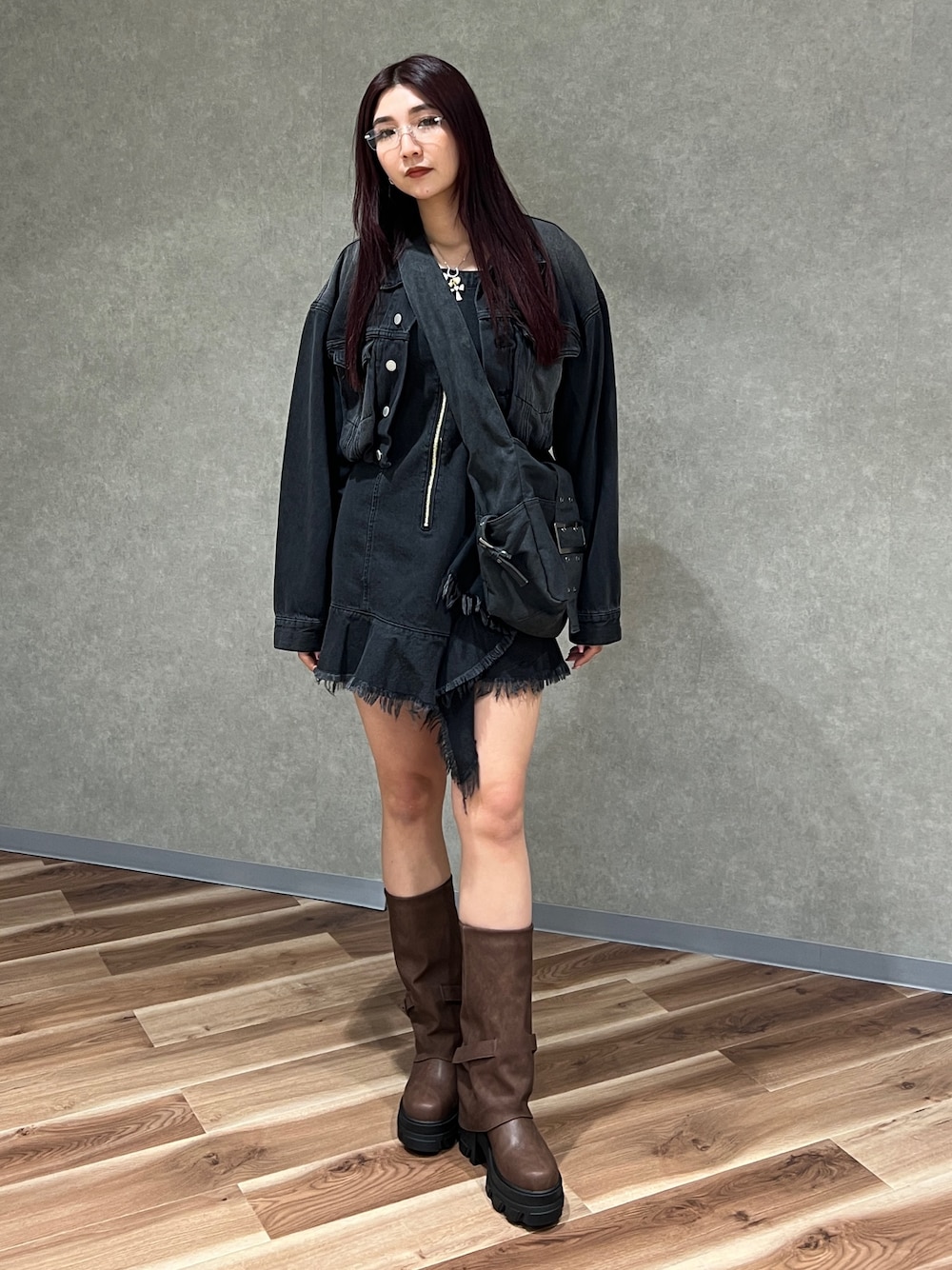 ブラック系のワンピース、ブラック系のデニムジャケット、ブラウン系のブーツを着用したレディースの冬コーディネートの1枚目の写真