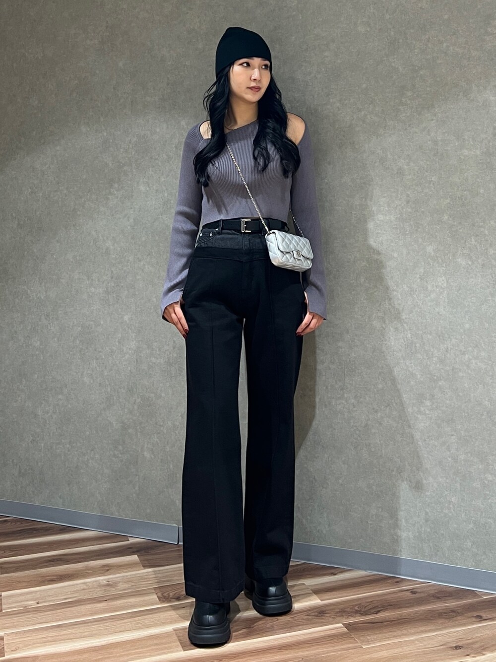 グレー系のニット/セーター、ブラック系のデニムパンツ、ブラック系のブーツを着用したレディースの冬コーディネートの1枚目の写真