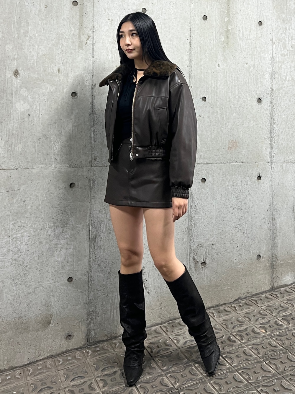 ブラック系のブルゾン、ブラウン系のスカート、ブラック系のブーツを着用したレディースの秋コーディネートの1枚目の写真