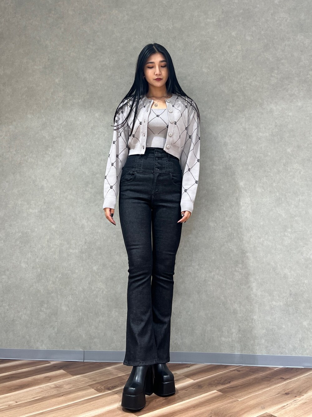 ブラック系のデニムパンツ、ブラック系のブーツ、グレー系のニット/セーターを着用したレディースの秋コーディネートの1枚目の写真