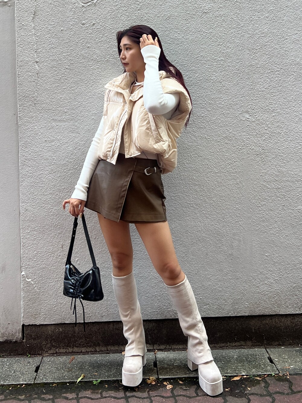 ホワイト系のダウンベスト、ホワイト系のニット/セーター、ブラウン系のその他パンツを着用したレディースの秋コーディネートの1枚目の写真